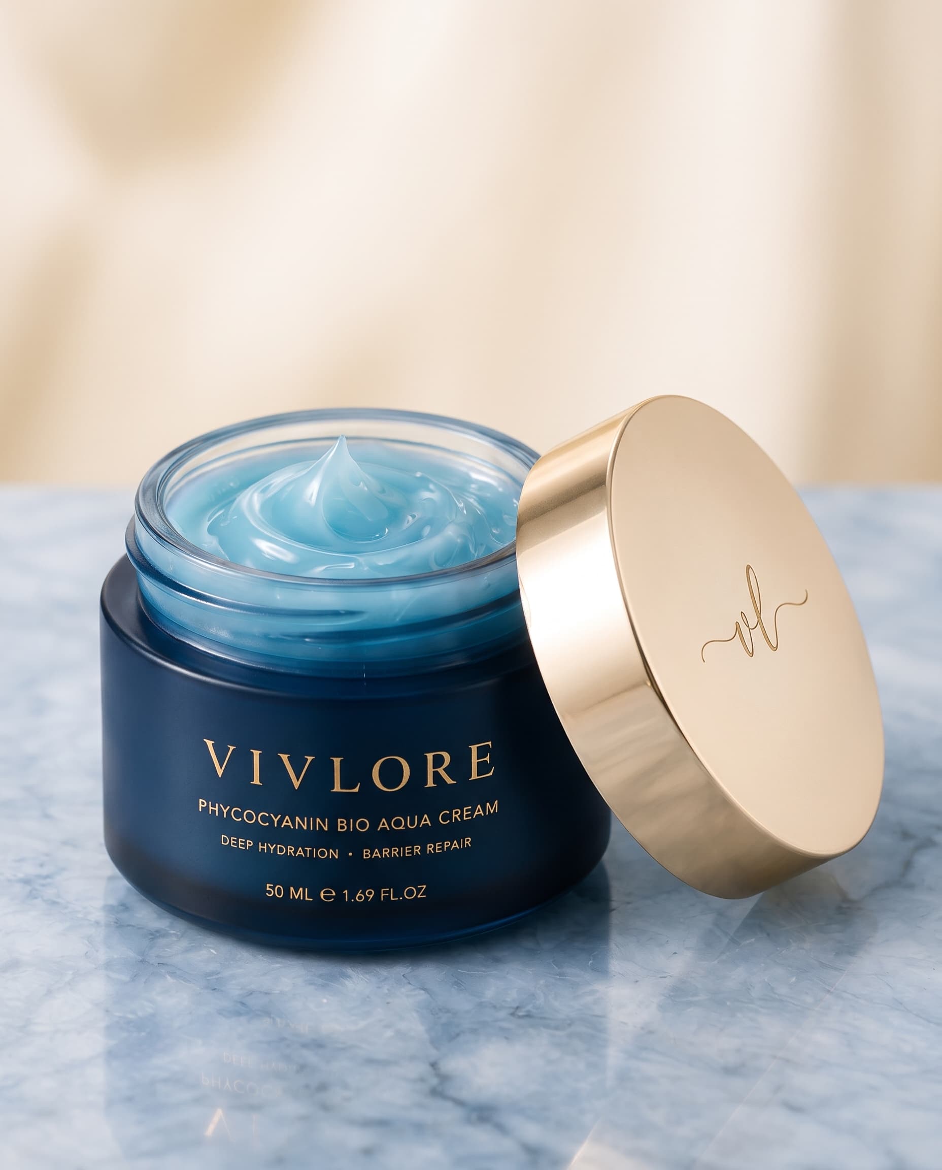 The open VIV LORE jar showing the aqua-blue gel cream, with the engraved gold lid resting beside it