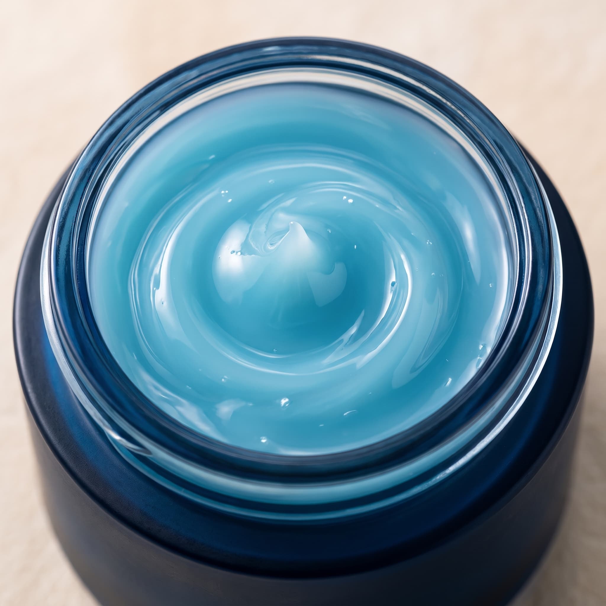 Close-up of the translucent aqua-blue gel cream swirled inside the navy jar