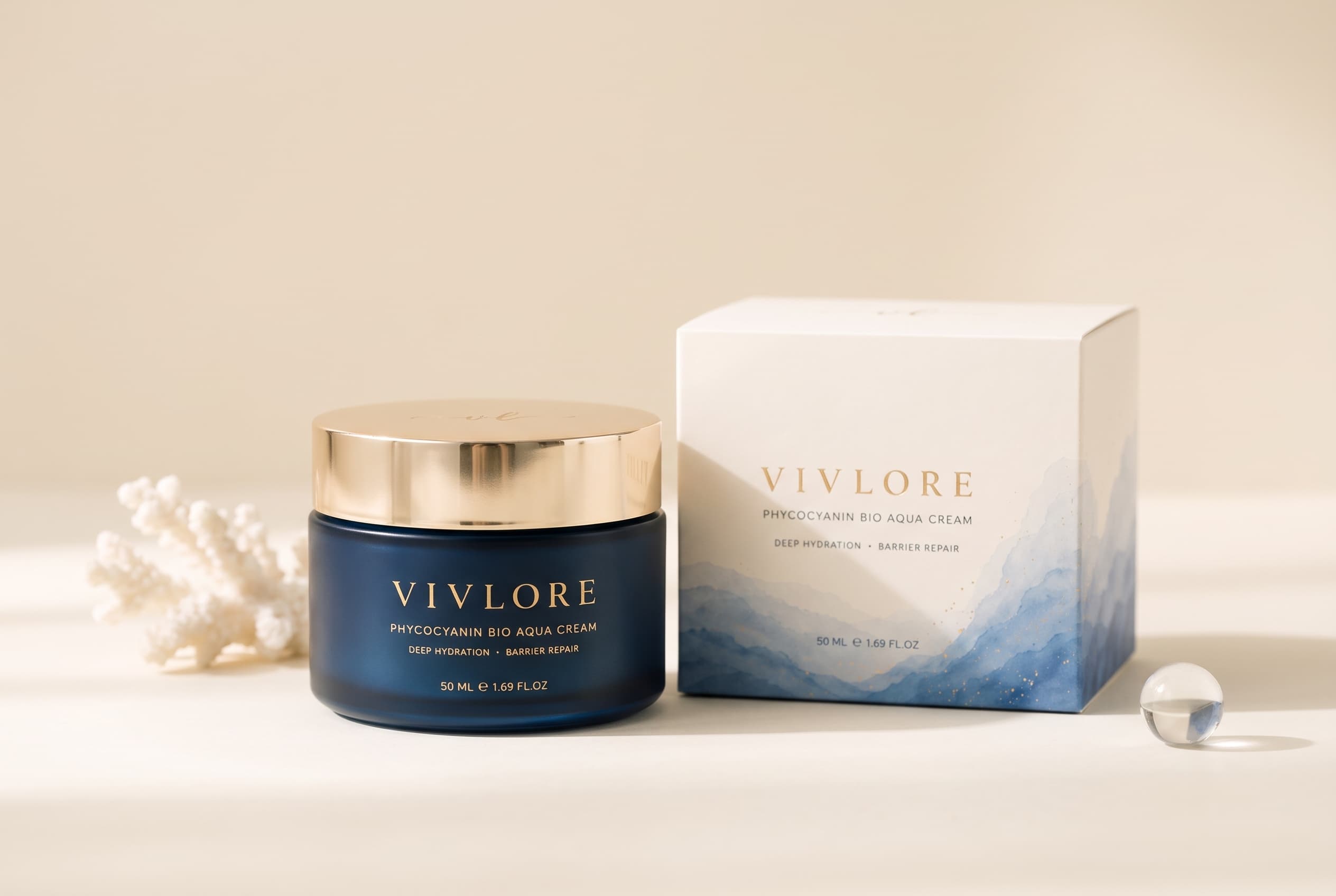 The VIV LORE jar beside its ivory box with watercolor ocean waves on a warm ivory surface